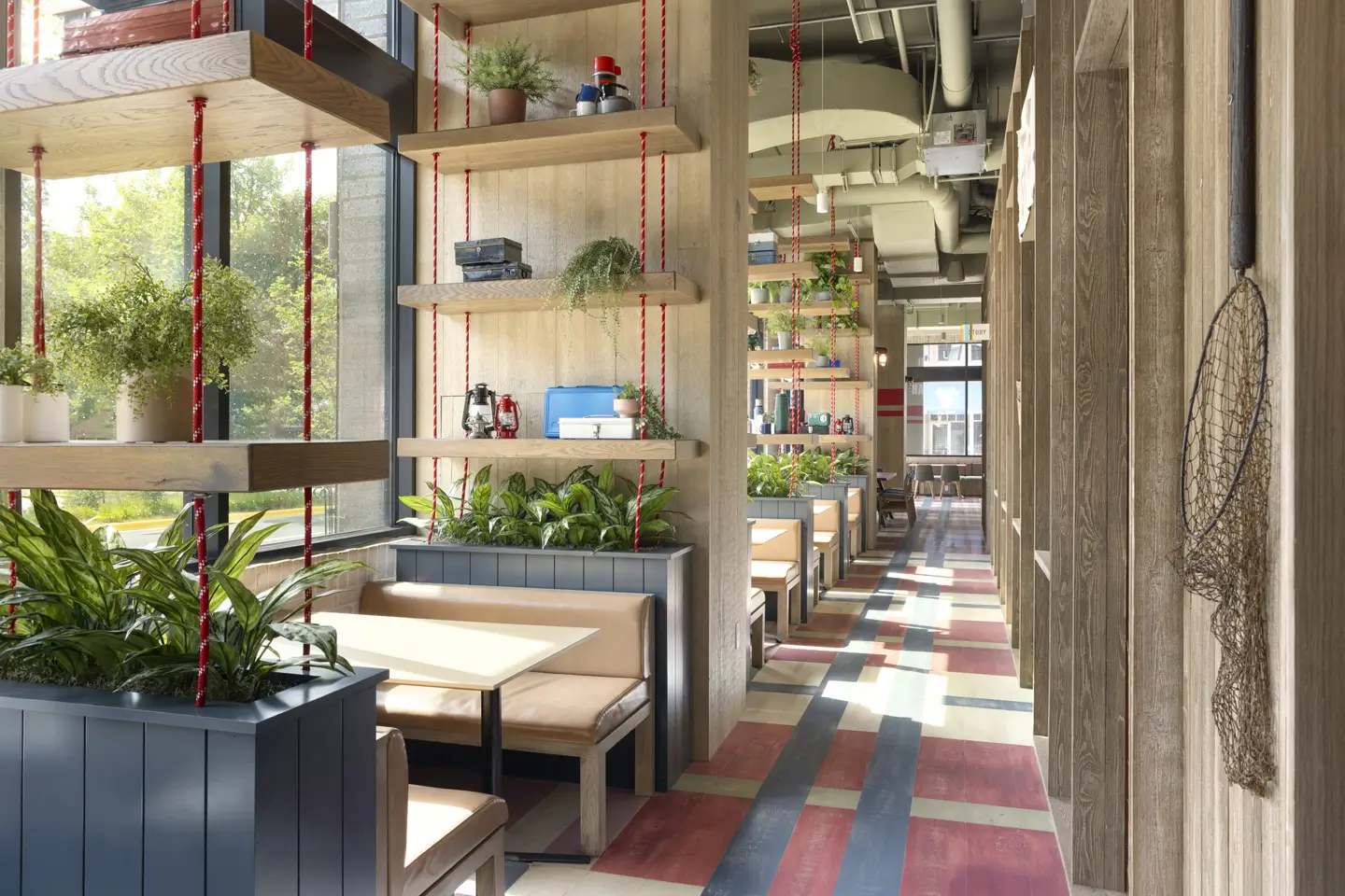 Fancy apartment lobby with large windows, shelving, and booth seating.