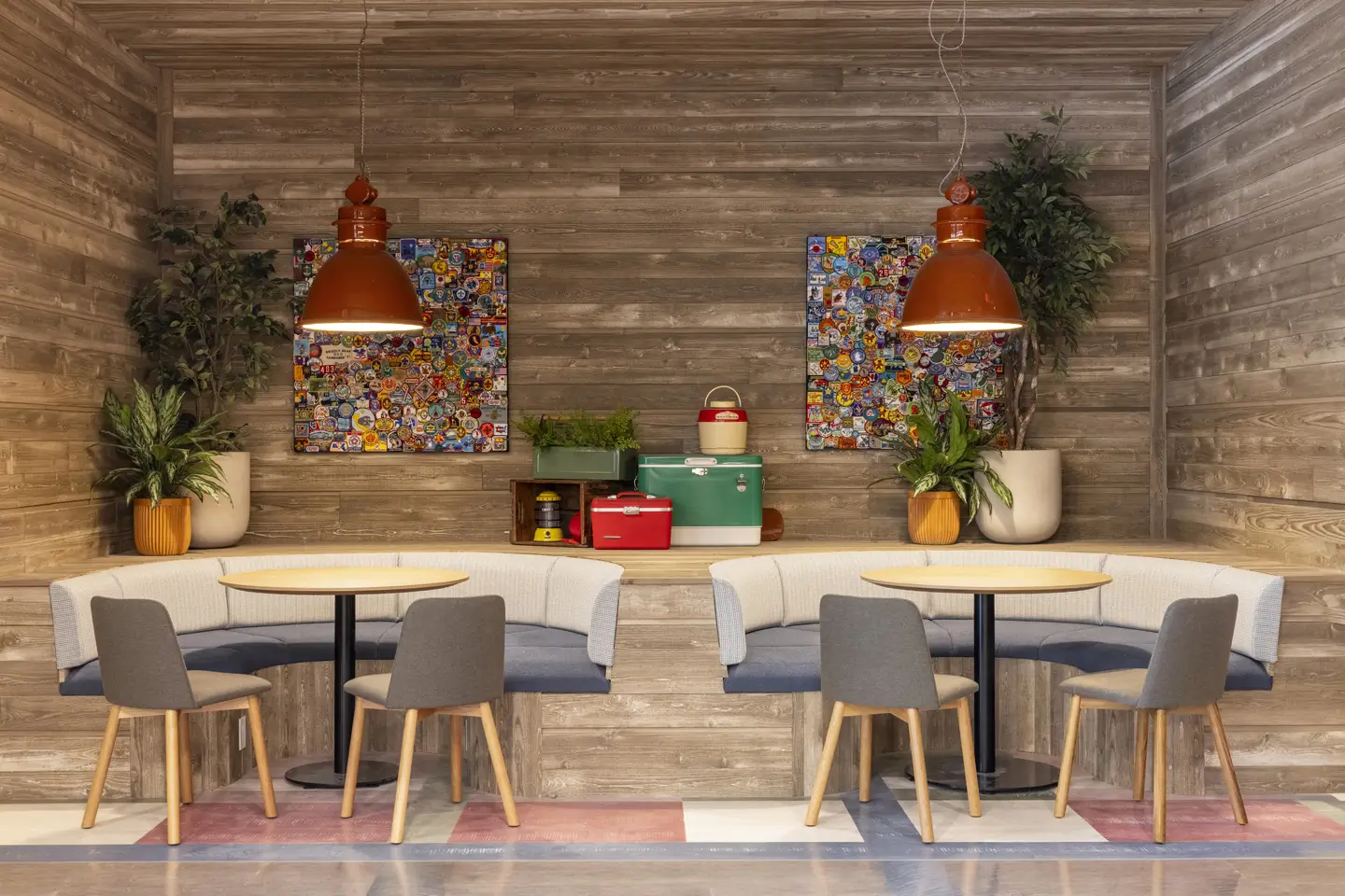 two tables with overhead lighting and a mixture of chair and booth seating.